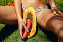 The Romantic vibrator by Smile Makers against a papaya