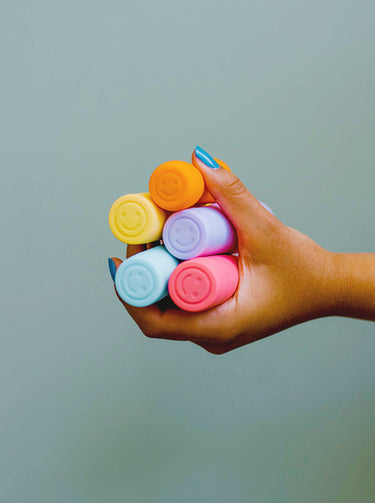 hand holding vibrators with smiles on the ends