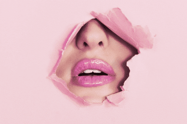 face with pink lipstick breaking through pink paper