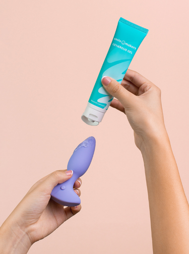 Hands holding a beginner-friendly anal plug with a flared base