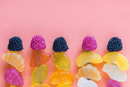 fruit candy kebabs on a pink background