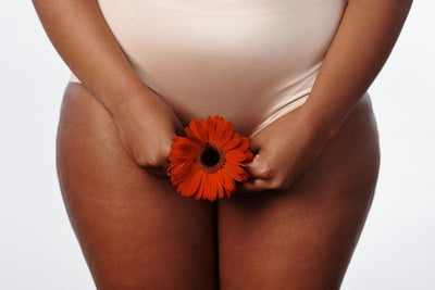 person holding a flower against their vulva