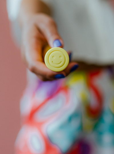 a yellow end of a vibrator with a smiley face