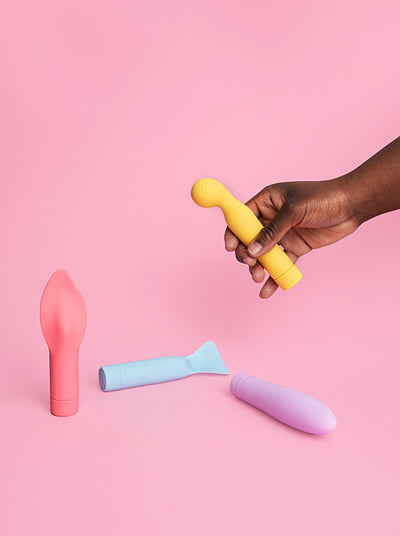 different colored vibrators on a pink background