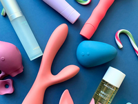 a flatlay of Smile Makers' vibrators, lube and candy canes on a navy blue background