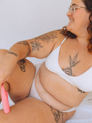 person holding a pink vibrator in their underwear